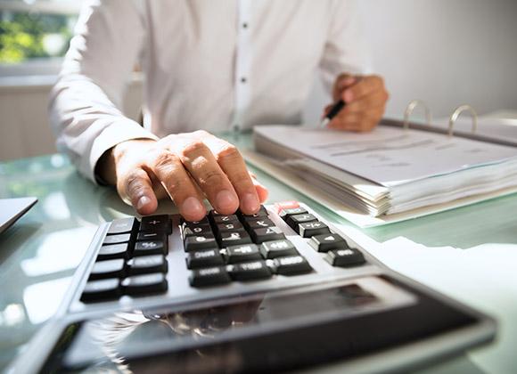 man doing calculations on a calculator as an accountant in Norcross